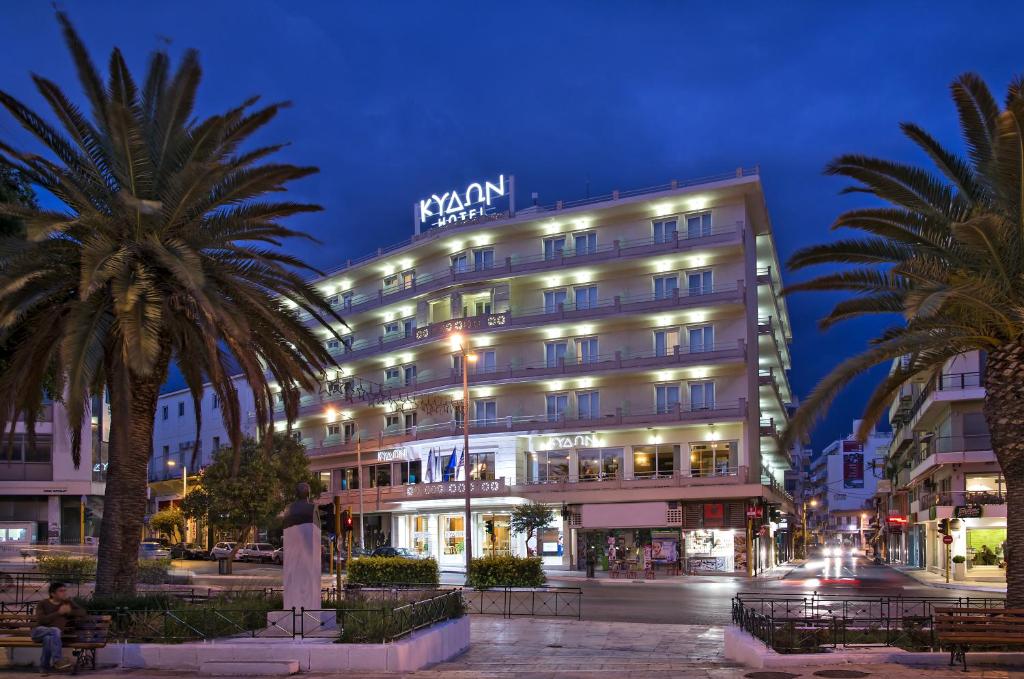 干尼亚Kydon The Heart City Hotel的一座酒店大楼前面有棕榈树