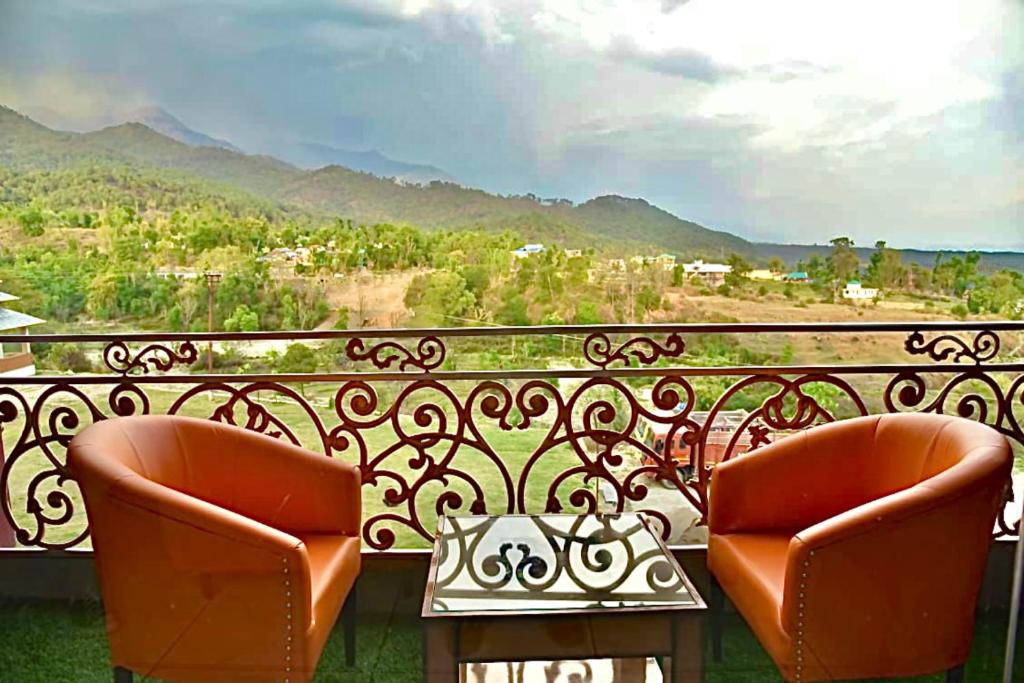 帕拉姆普尔Jai Hotel By Boho的两把椅子坐在一个美景阳台