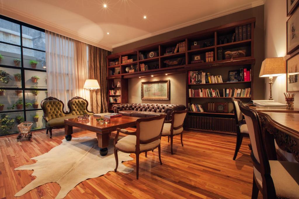 蒙得维的亚阿尔玛古典精品酒店的客厅配有桌椅和书架