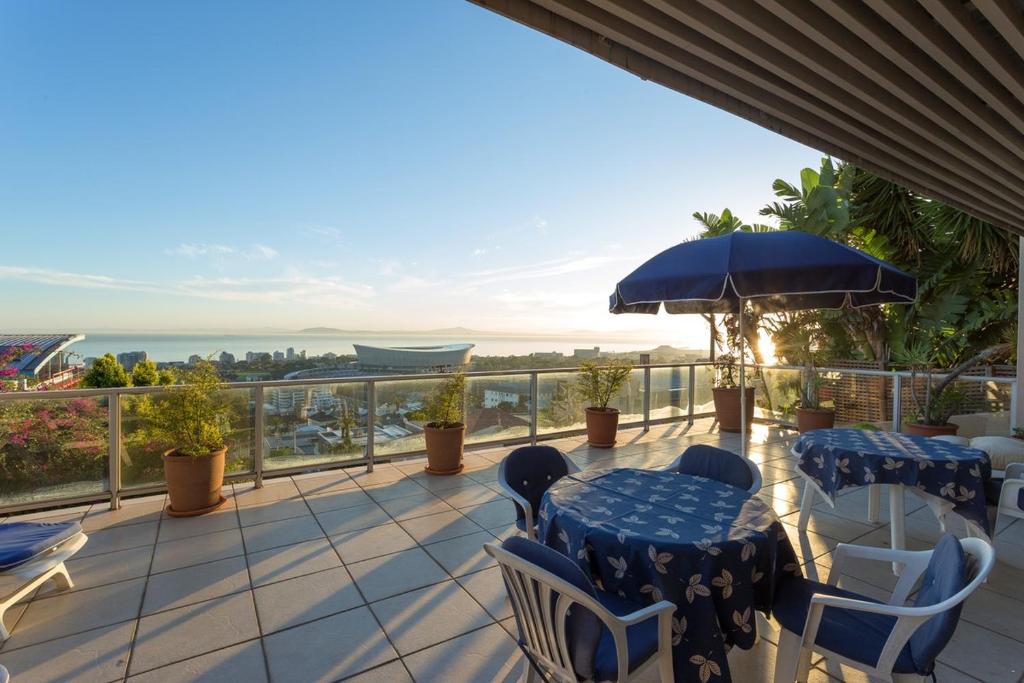 开普敦Villa Marina Guest House的阳台配有桌椅,享有海景。