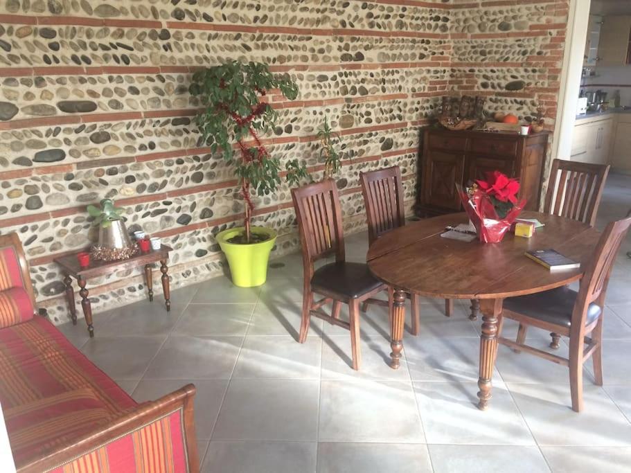 图卢兹Magnifique maison toulousaine的一间带木桌和椅子的用餐室