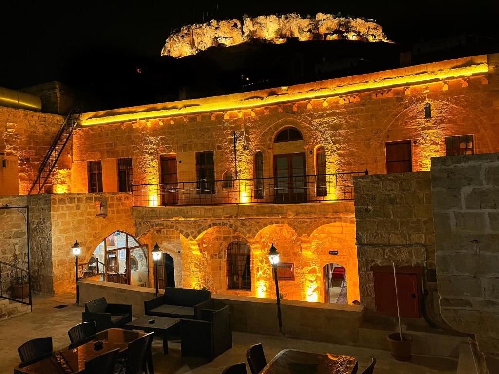 马尔丁Fairouz Konak Otel的一座大型砖砌建筑,晚上有灯