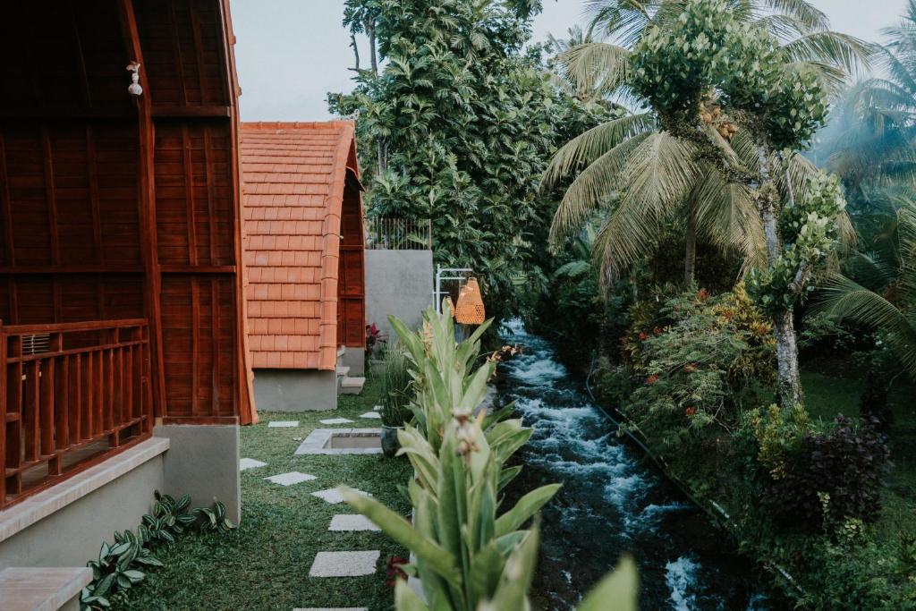 AmbenganKubu River View的一座花园,房子中间有一条小溪