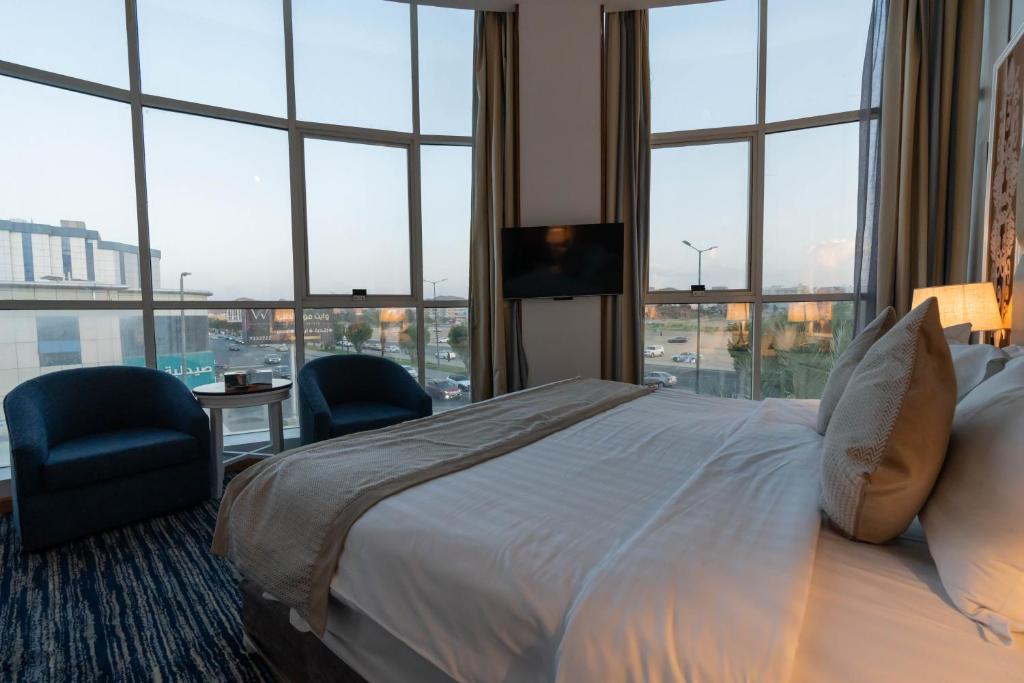 塔伊夫Platinum Al Khamseen的酒店客房带一张床、椅子和窗户
