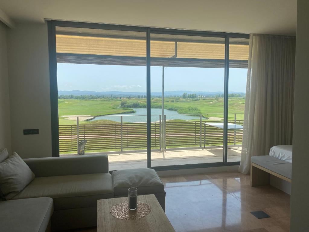 GualtaModerno apartamento en Empordà Golf的带沙发和大窗户的客厅