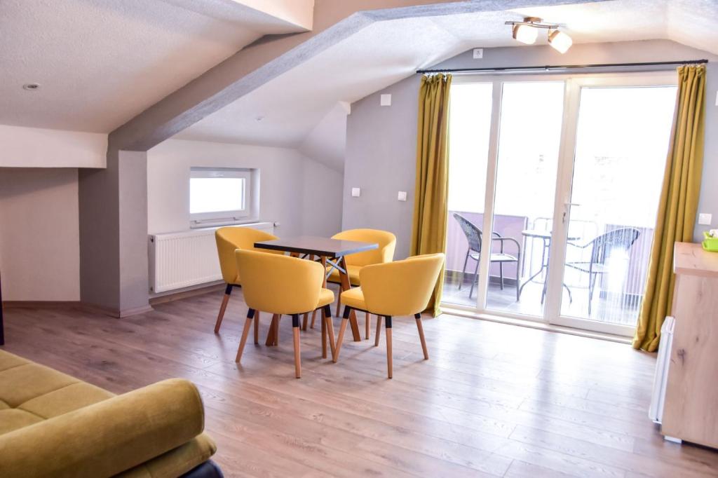 克鲁舍沃Papi Apartments的客厅配有桌子和黄色椅子