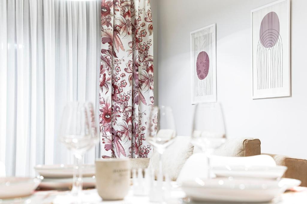 特里卡拉Quattro Luxury Apartments的用餐室配有带盘子和酒杯的桌子