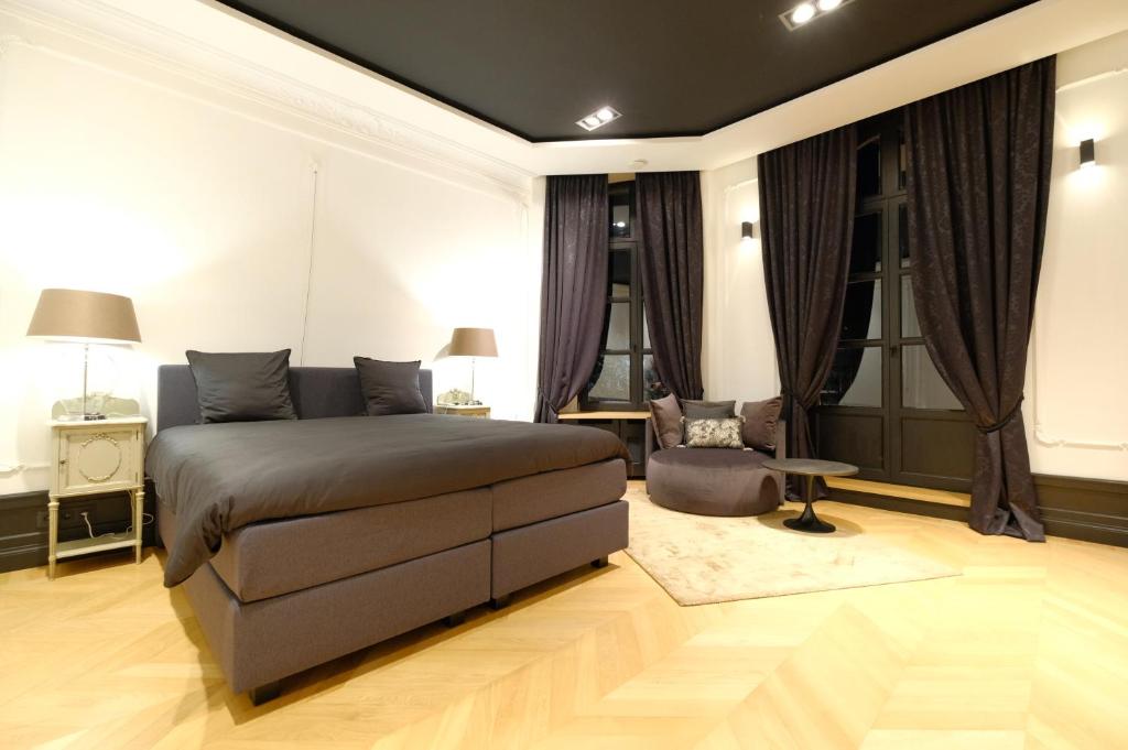 蒙斯Suite la Duchesse et Parking privé gratuit的卧室配有1张床、1张桌子和1把椅子