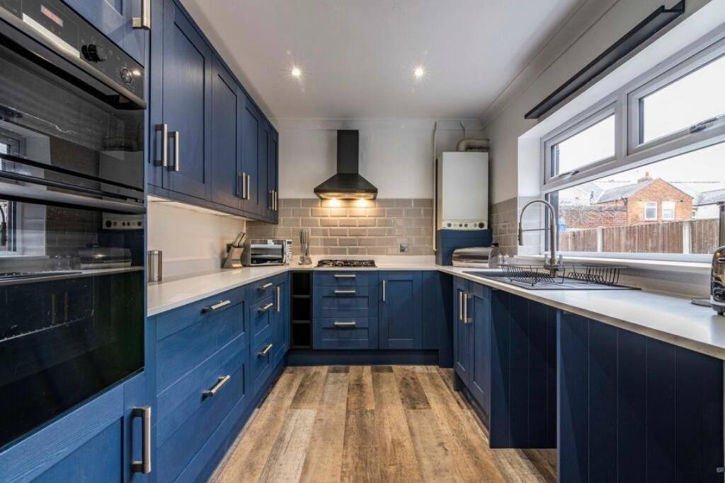 曼斯菲尔德Westfield 3 Bed Characterful and Modern House FREE PARKING and private garden的厨房配有蓝色橱柜和窗户。