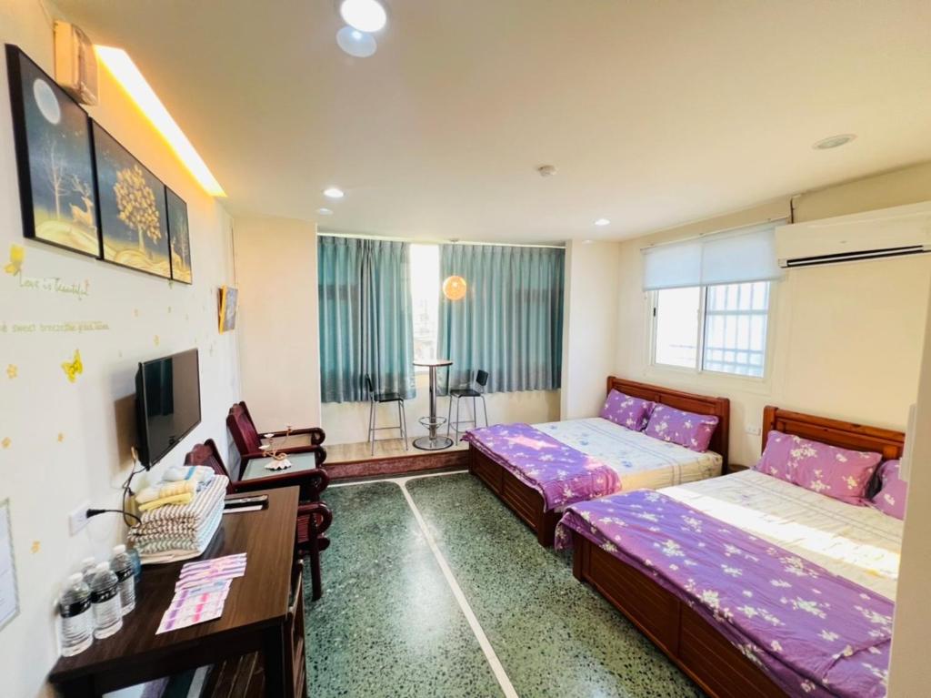 Xingang番路乡居民宿的客房设有两张床、一张桌子和一台电视机。