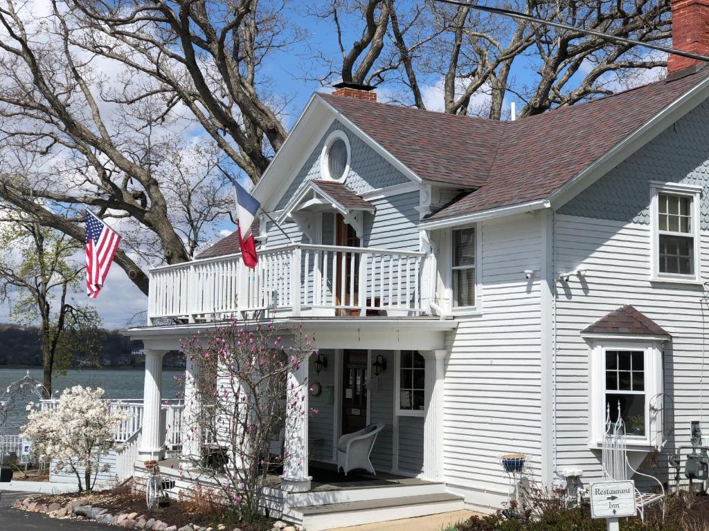 日内瓦湖The French Country Inn的带阳台和美洲国旗的白色房屋