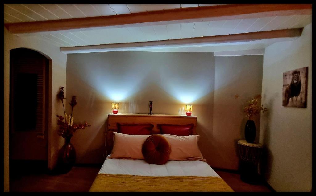 贝尔南Lion-Les Jardins de Kuz的卧室配有一张床,墙上挂着两盏灯