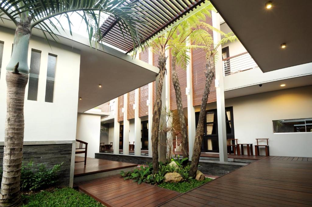 玛琅舒适精品旅馆的一座种植了棕榈树的庭院