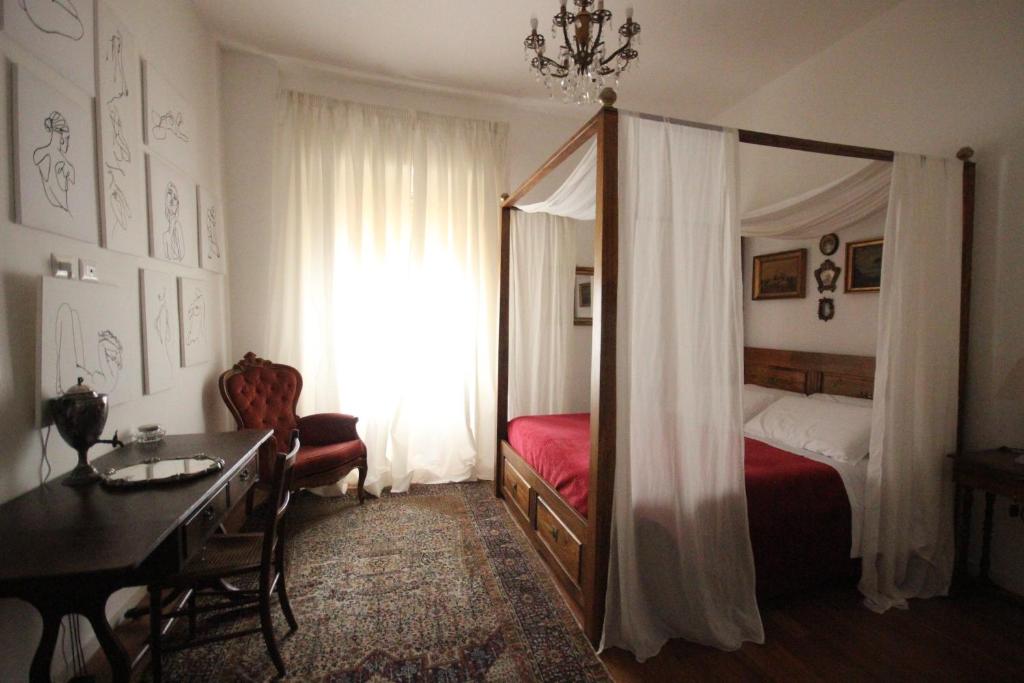 卡利亚里Il Chiostro的一间卧室配有一张床、一张书桌和一面镜子
