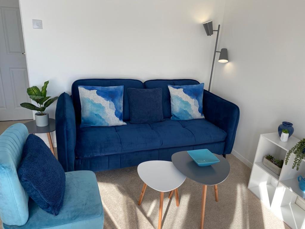 亨斯坦顿Close to beach. Two bed compact flat.的客厅配有蓝色的沙发和桌子