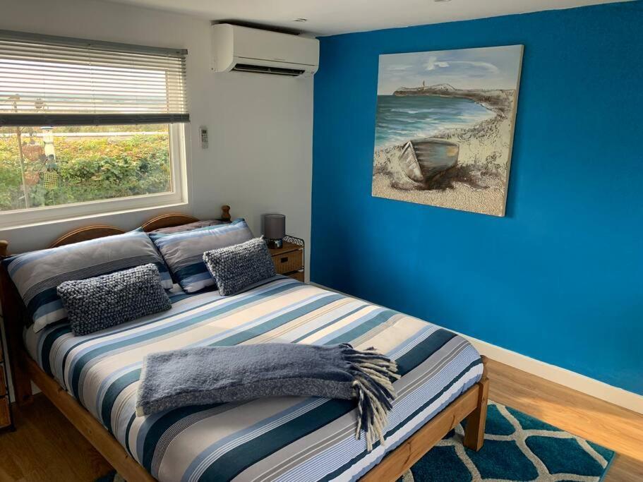 布里斯托Old Ferry View的一间卧室设有蓝色的墙壁和一张带窗户的床