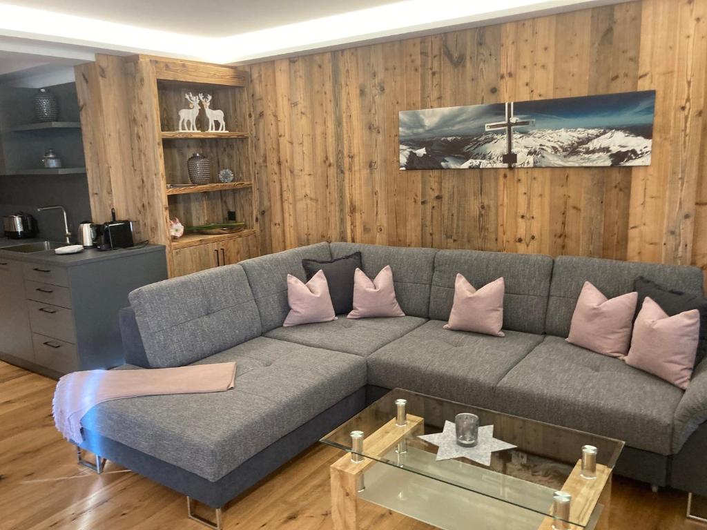 蒂罗尔-基希贝格Lodge14的客厅配有带粉红色枕头的灰色沙发