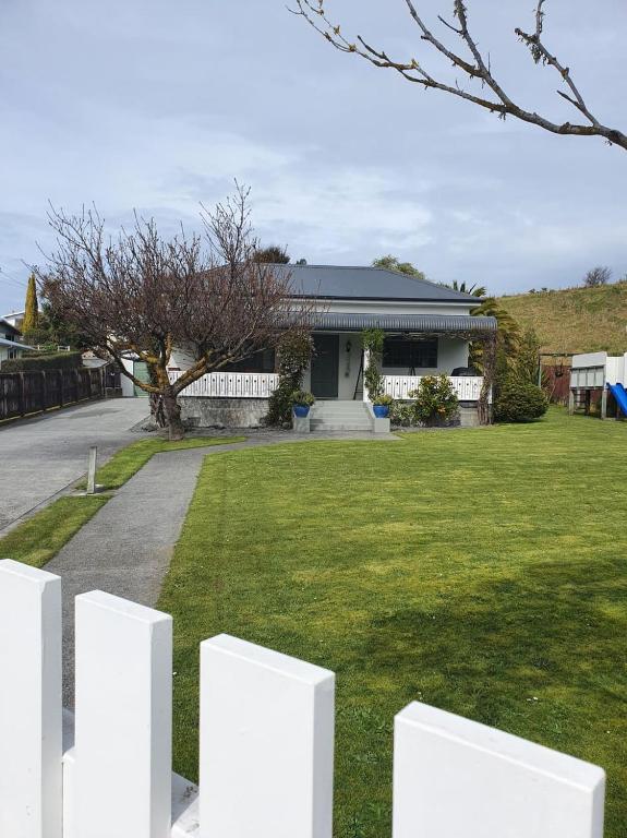 凯库拉Ludstone Villa - A charming family home的房屋前的白色栅栏