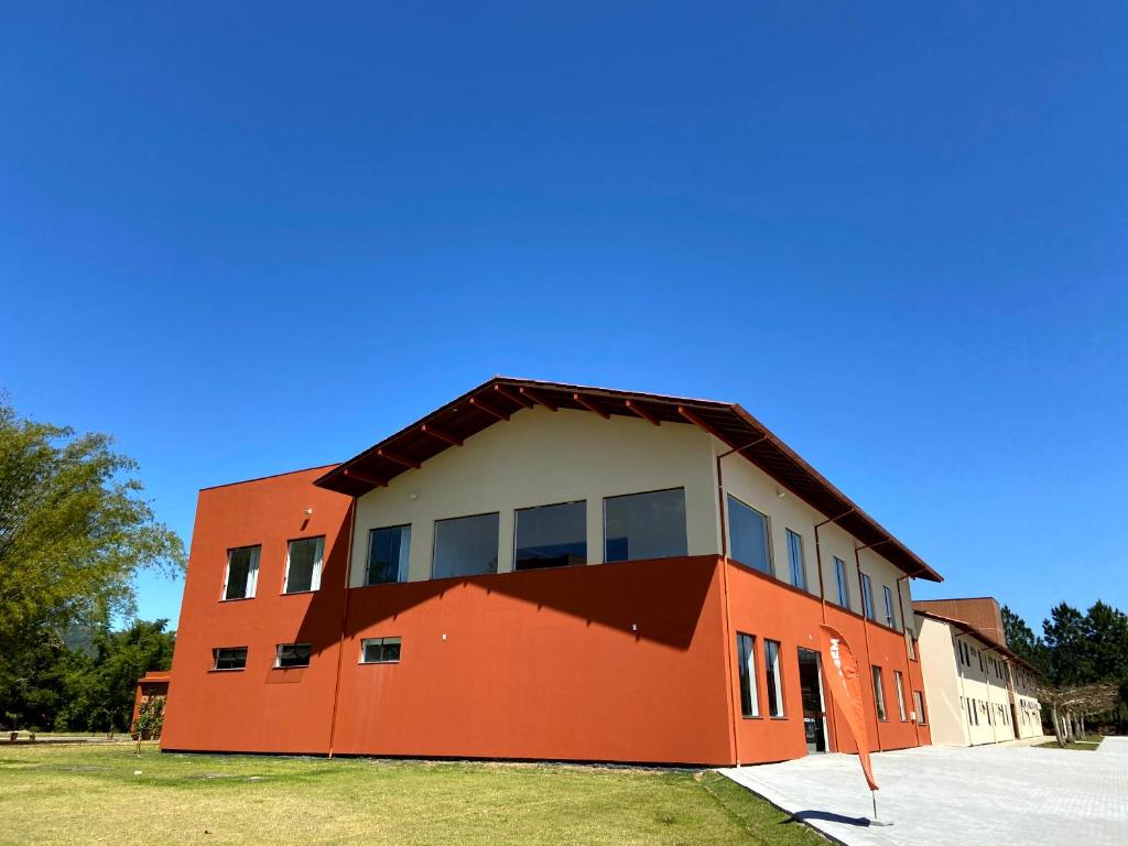 塞尔苏拉穆斯州长镇Pousada Divino Oleiro - Gov. Celso Ramos的一座橙色的建筑,窗户在建筑的一侧