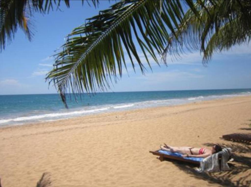 本托塔雅努斯天堂休憩住宿加早餐旅馆的躺在棕榈树下海滩上的人