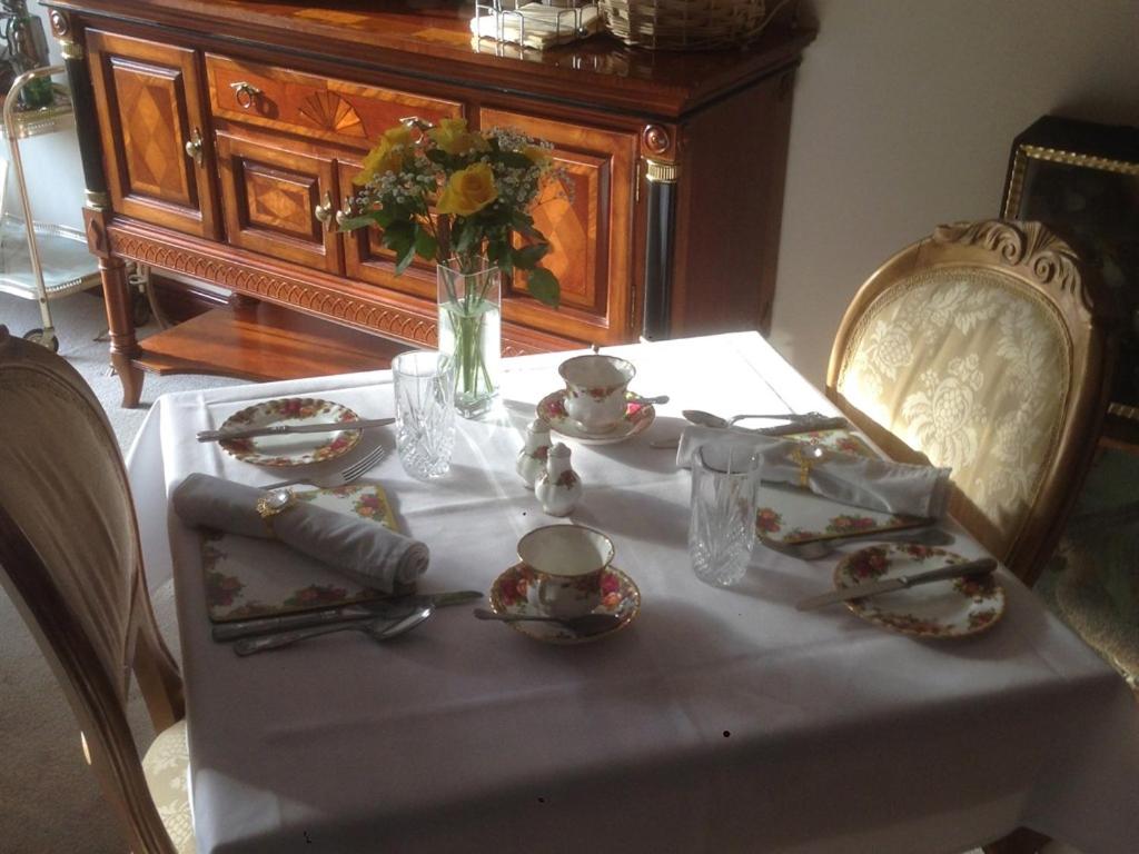 费克纳姆Melody House的一张桌子,上面有白色的桌布和花瓶
