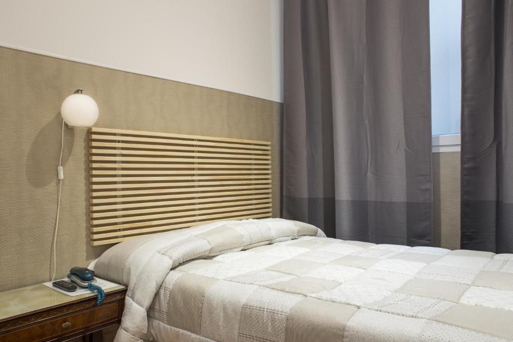佛罗伦萨佛罗伦萨洛吉尔酒店的一间卧室配有床、灯和窗户