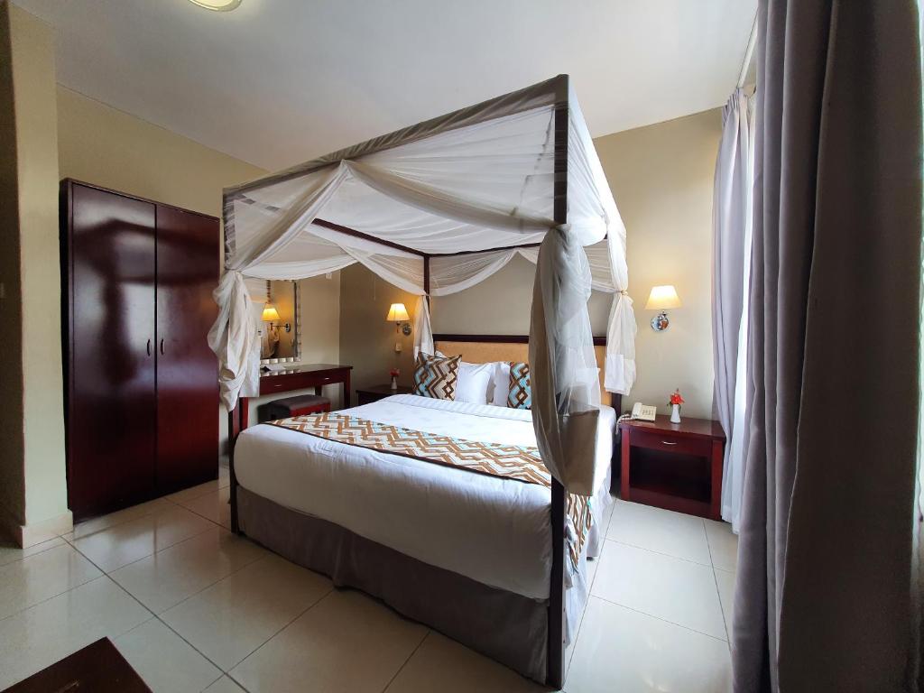布兰太尔赛伦迪布套房和会议中心酒店的一间卧室配有一张带天蓬的大床