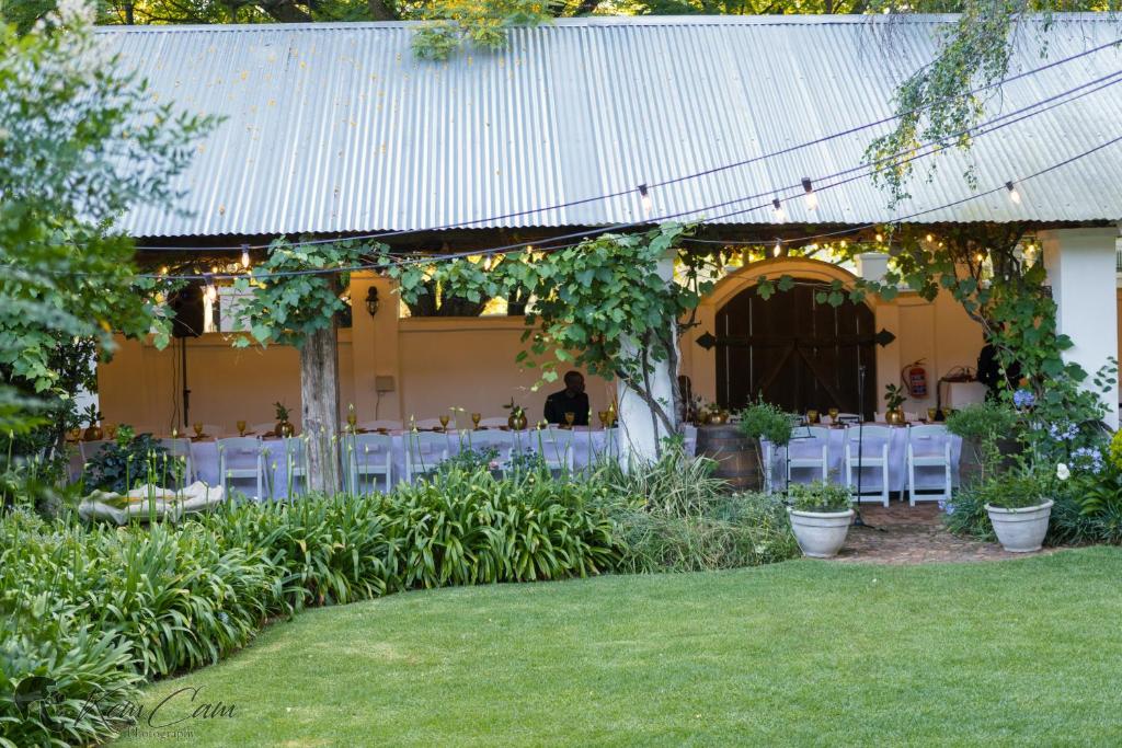 肯普顿帕克55 Tulbagh events and wedding venue的花园内带白色桌椅的帐篷