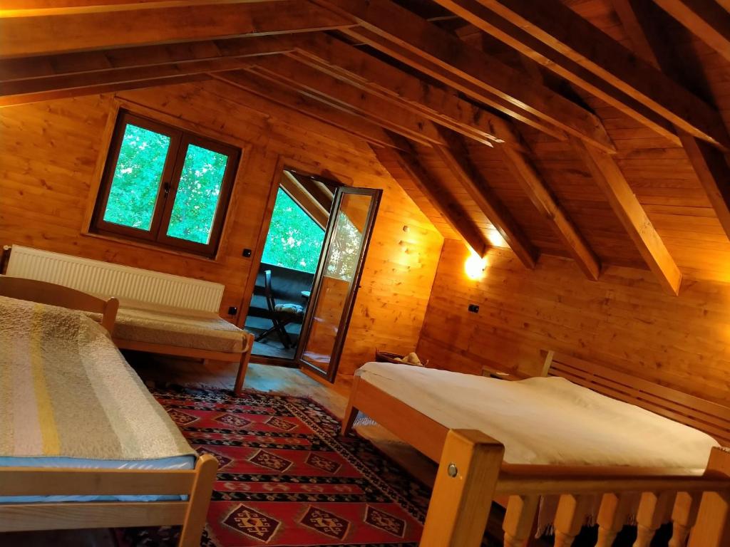 比哈奇Kuća u šumi - Forest house near National park Una - Air Spa Lohovo的小屋内带两张床和窗户的房间