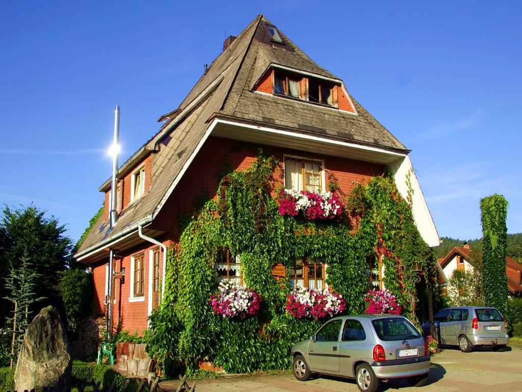 蒂蒂湖-新城Haus am Tannenhain的一座常春藤覆盖的房子,前面有一辆汽车