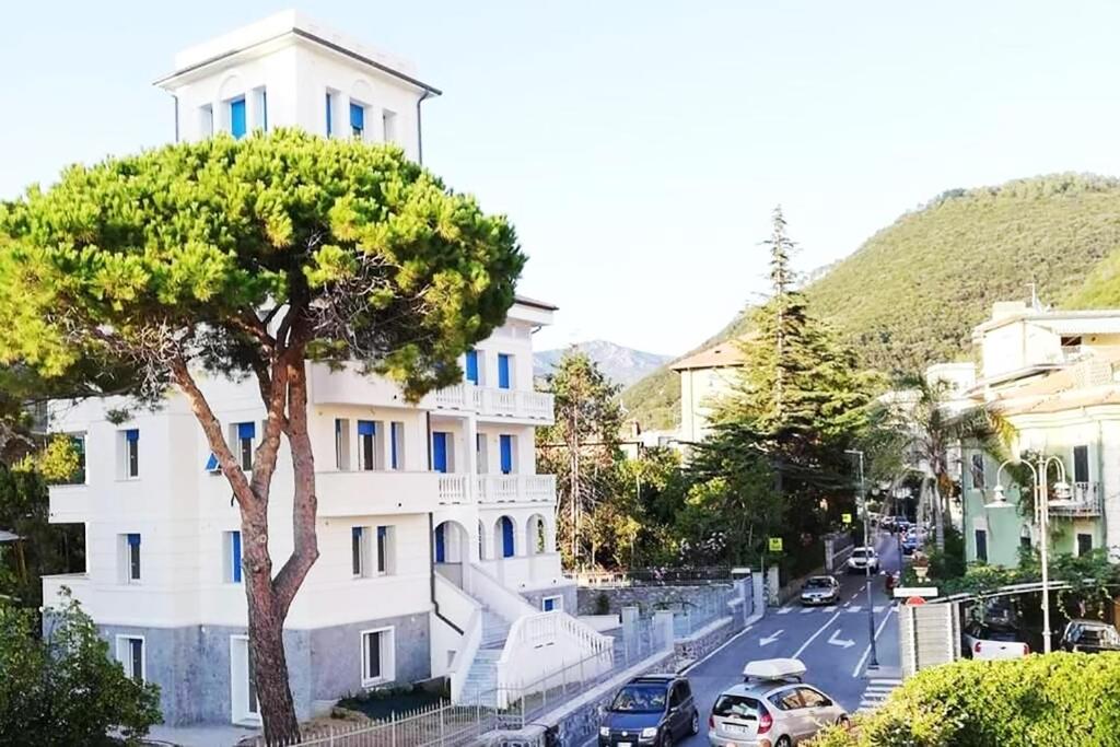 德瓦玛丽娜Villa Schiaffino Appartamento al Primo Piano的街道旁的白色建筑,树