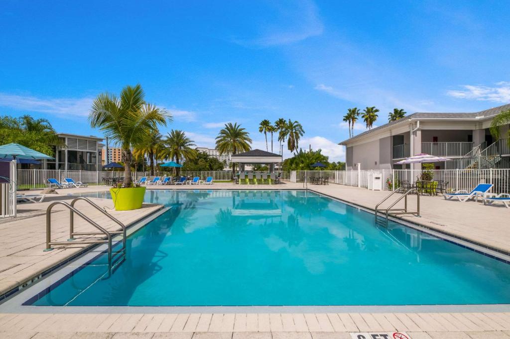 奥兰多Clarion Inn & Suites Across From Universal Orlando Resort的棕榈树度假村的游泳池