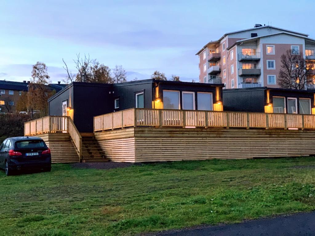 基律纳Private Chalet with Sauna的草上带大甲板和汽车的房子