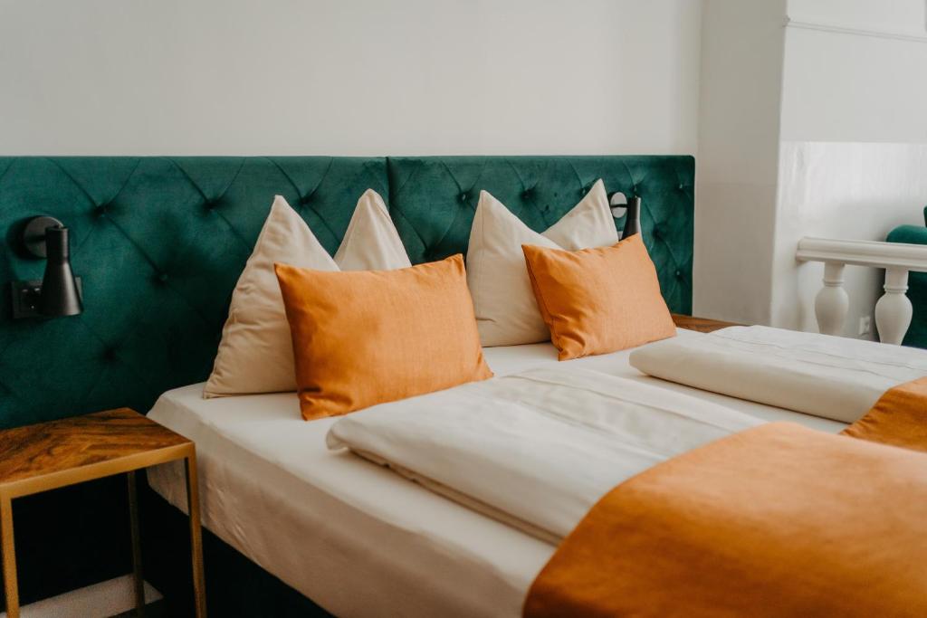 菲拉赫Hotel Palais26的两张带橙色和白色枕头的床