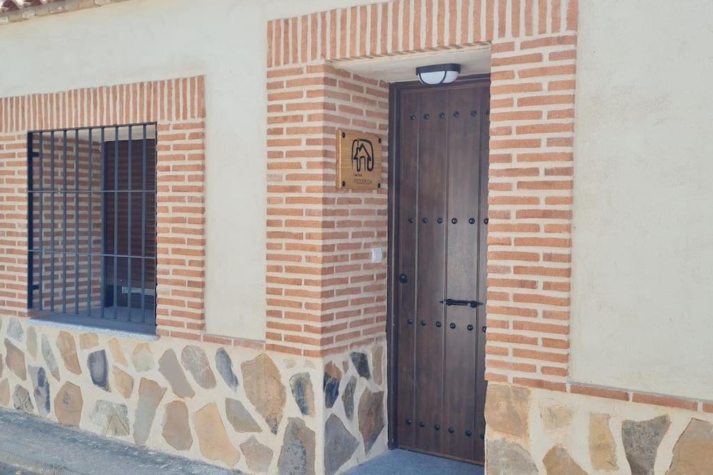 GuadamurCasa FIGUEROA en Guadamur, próximo a Puy du Fou的砖砌建筑上一扇门,上面有标志