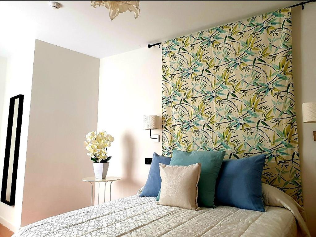 塞维利亚LHome的一间卧室配有一张带花卉图案墙壁的床