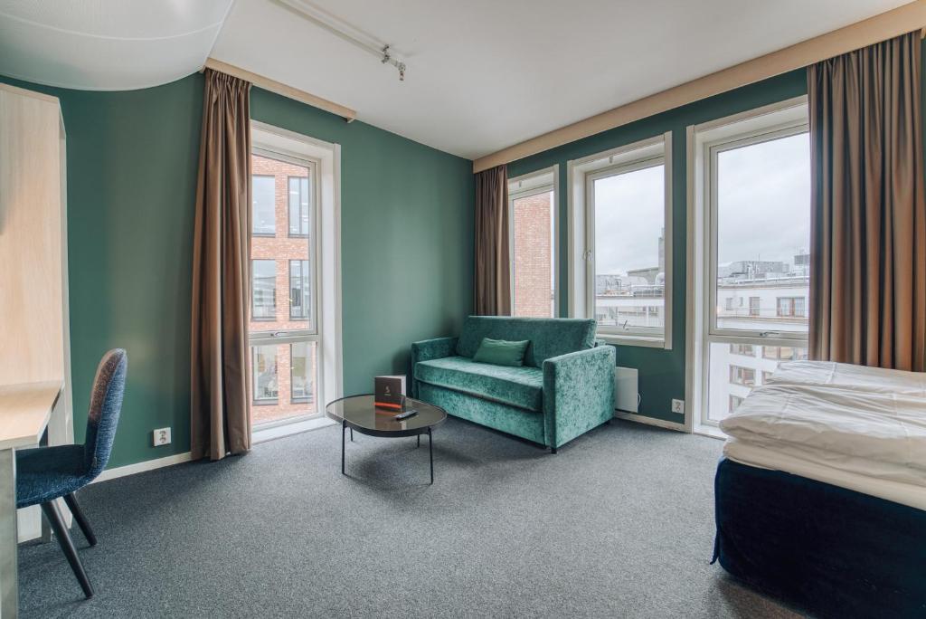 奥斯陆奥斯陆智能酒店的一间卧室配有一张床、一张沙发和一张桌子