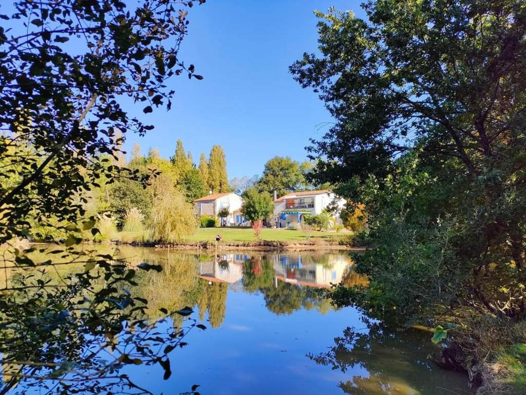 Saint-Avaugourd-des-LandesGîte Douceur de vivre的享有树木和房屋的湖泊美景。