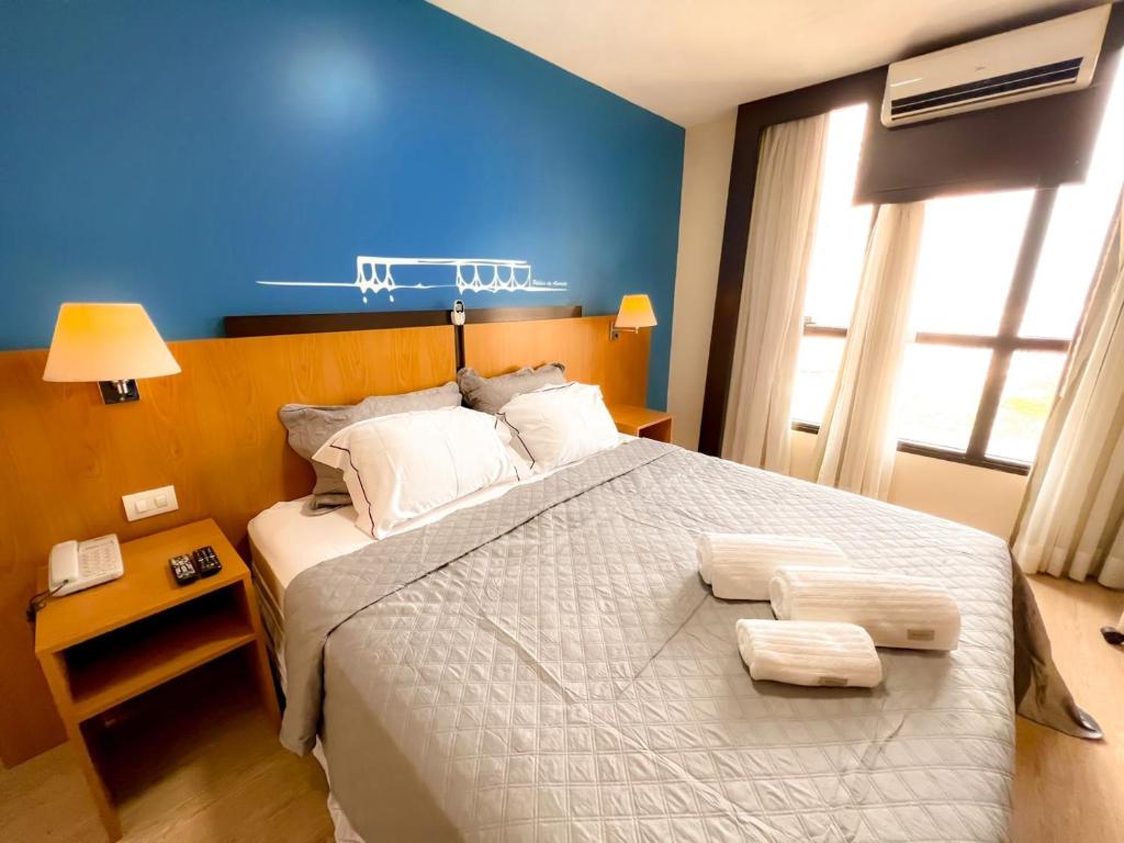 巴西利亚Flat 1015 - Comfort Hotel Taguatinga的一间卧室设有一张蓝色墙壁的大床