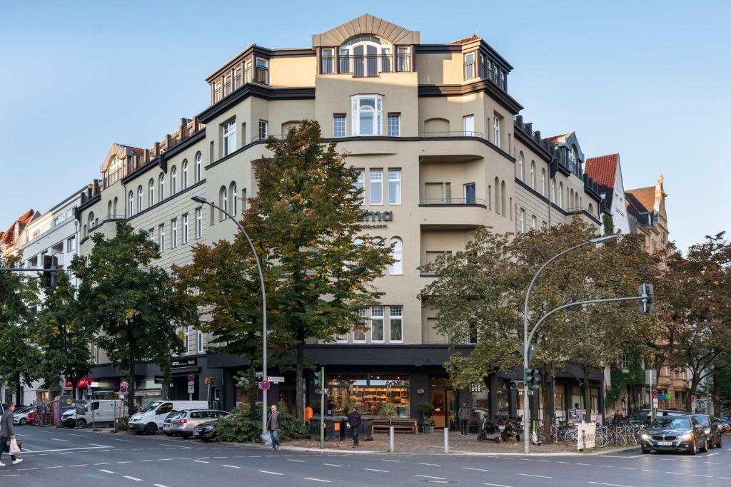 柏林numa I Novela Rooms & Apartments的一条城市街道上一座大型建筑,前面有汽车停放