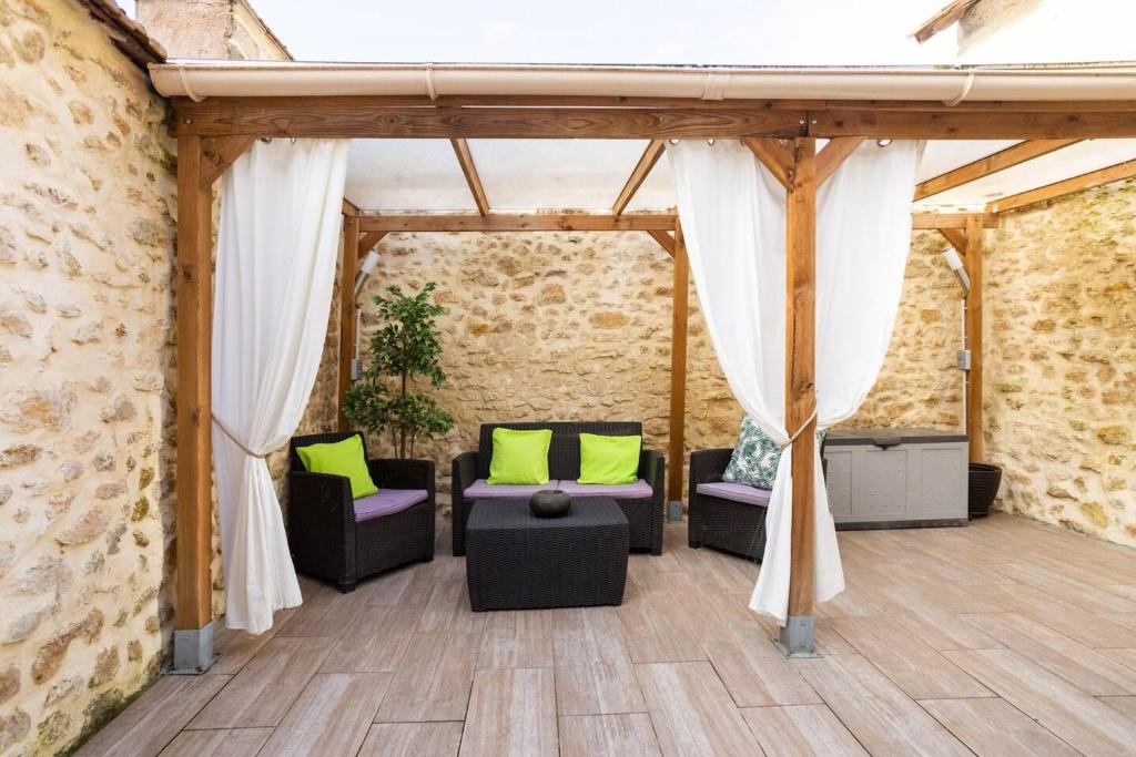 Noyen-sur-SartheMaison d'une chambre avec terrasse amenagee et wifi a Noyen sur Sarthe的砖墙内的房间,配有沙发和椅子