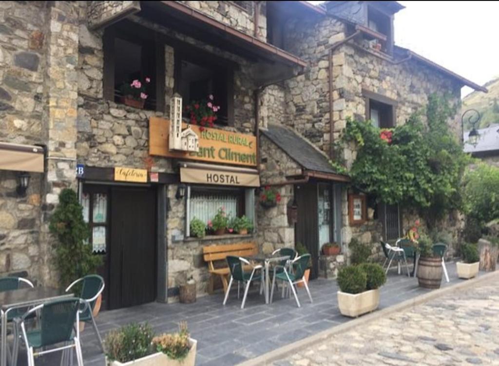 陶尔Hostal Rural Sant Climent的大楼外带桌椅的餐厅