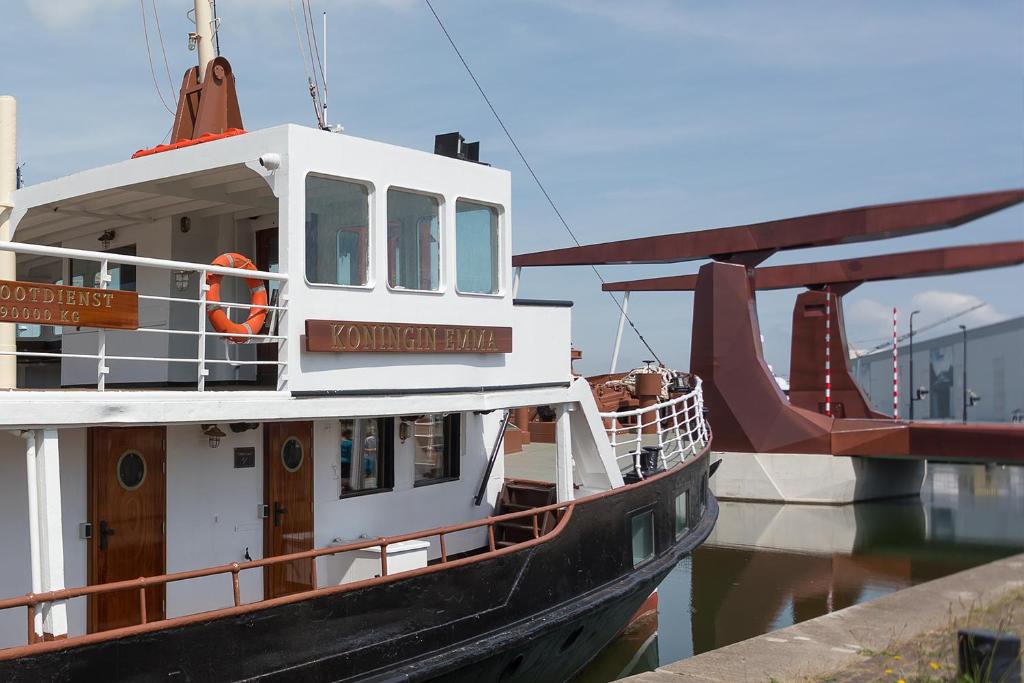 弗利辛恩Hotelboot Koningin Emma I Kloeg Collection的船停靠在水面上的码头