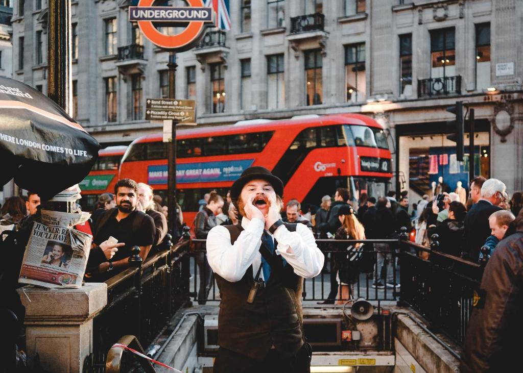 伦敦Stay at Piccadilly的站在繁忙的城市街道上,用手机说话的人