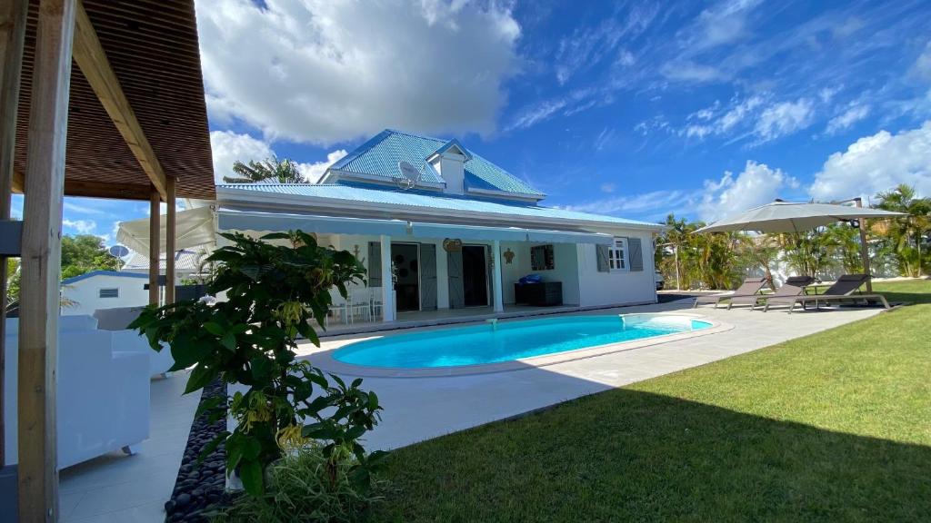 圣弗朗索瓦Villa Nomilou Beach avec Accès direct Plage的庭院中带游泳池的房子