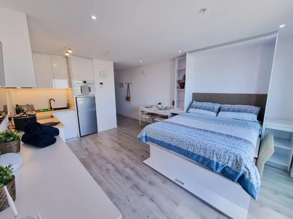 直布罗陀Brand New Top Floor Studio - The Hub Gibraltar - Self Catering的一间设有床铺和厨房的大卧室