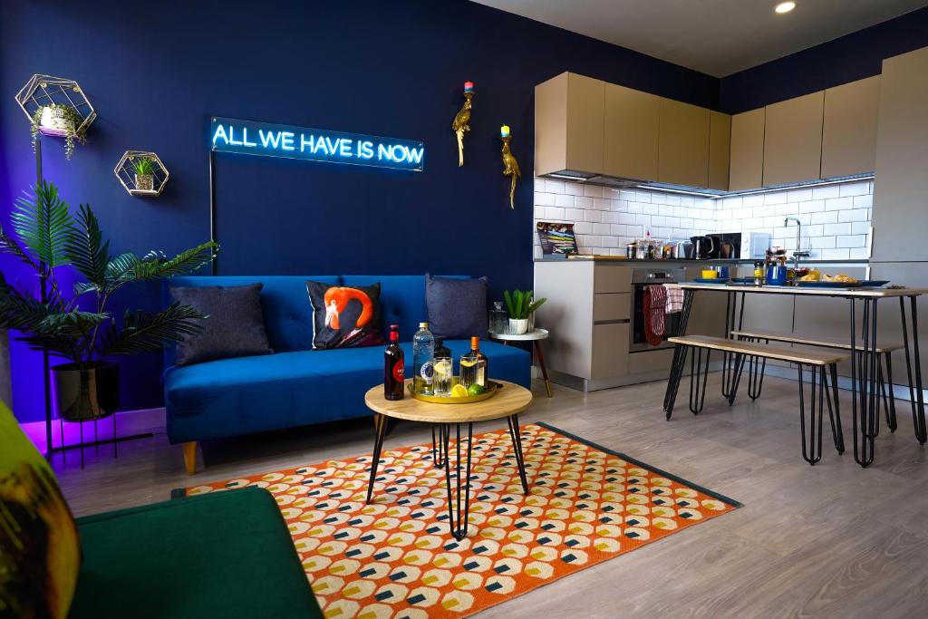斯蒂夫尼奇Luxury Stevenage Town Centre Apartment的客厅配有蓝色的沙发和桌子