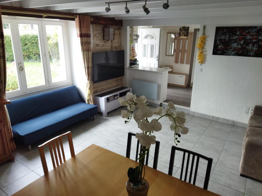Saint-Michel-le-CloucqCharmante maison的客厅配有桌子和蓝色沙发
