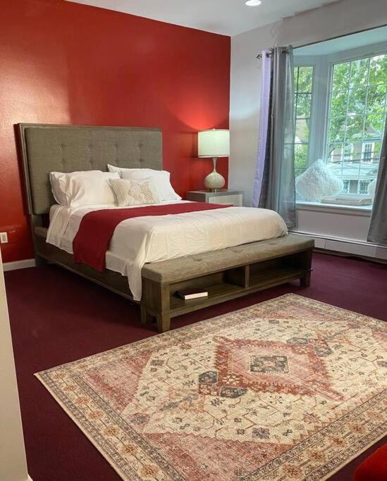 布鲁克林Room at The Oasis的一间卧室设有一张红色墙壁的大床