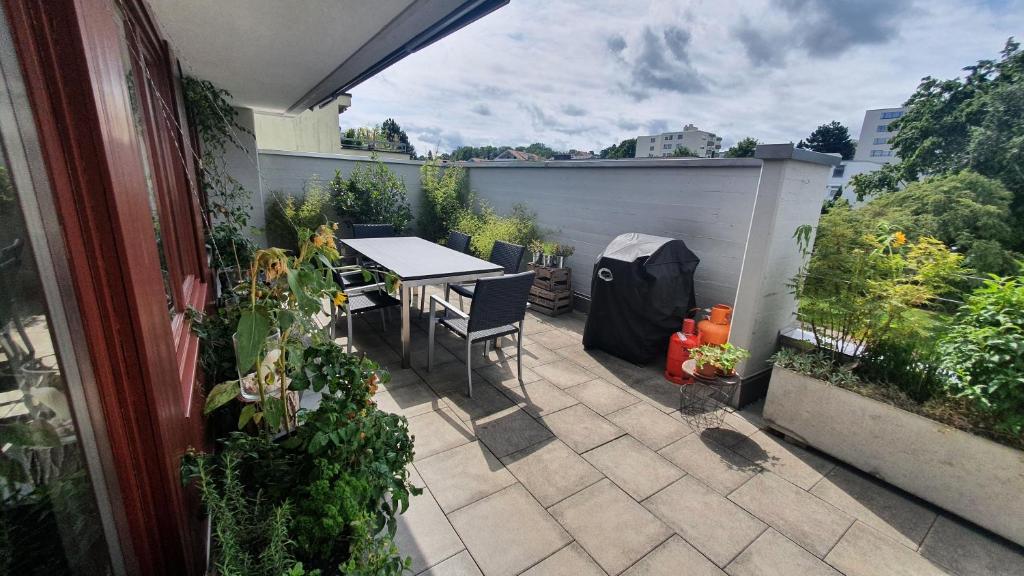 克罗伊茨林根COSI - Komfortables Privatzimmer mit grosser Terrasse und Parkplatz的庭院配有桌椅和植物